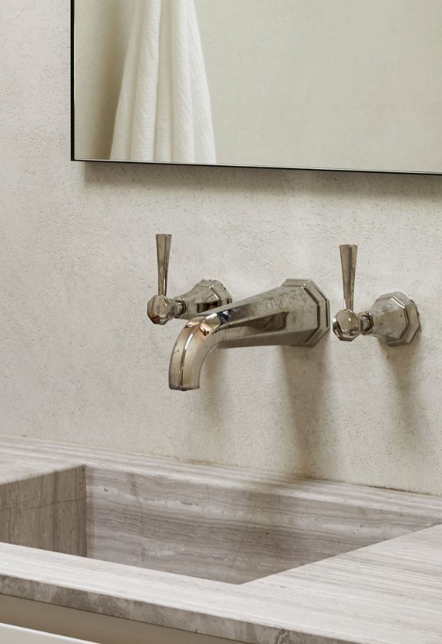 Nickel Art Deco basin taps with octagonal faceted detail show aging patination in traditional setting above marble sink.